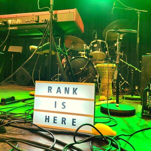 "RANK IS HERE" skilt på scenen